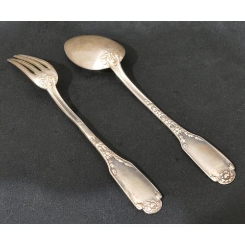 300 - A pair of Continental silver coloured metal christening spoon and fork with raised scroll and leaf d... 