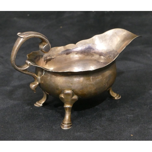 309 - A Georgian silver small sauce boat with crinkle rim, scroll handle, on hoof feet, 12cm long, 3.2oz (... 