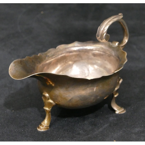 309 - A Georgian silver small sauce boat with crinkle rim, scroll handle, on hoof feet, 12cm long, 3.2oz (... 