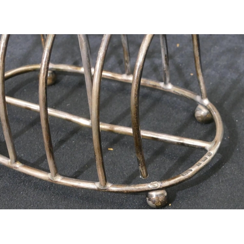 311 - A Birmingham oval silver 5-bar toast rack with centre carrying handle and on ball feet, 10.5cm long,... 