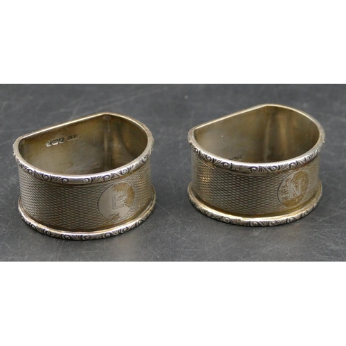 340 - A pair of Birmingham silver arched topped napkin rings with engine turn decoration, makers mark C&N,... 