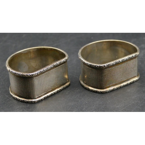 340 - A pair of Birmingham silver arched topped napkin rings with engine turn decoration, makers mark C&N,... 