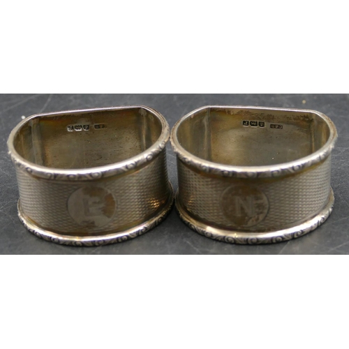 340 - A pair of Birmingham silver arched topped napkin rings with engine turn decoration, makers mark C&N,... 