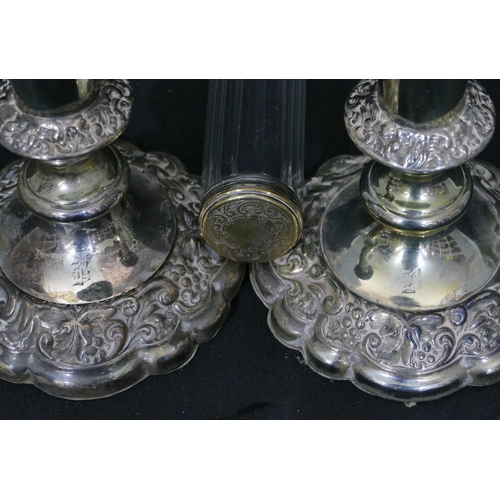 359 - A pair of silver plated candlesticks on turned stems with round scallop shaped bases, embossed flora... 