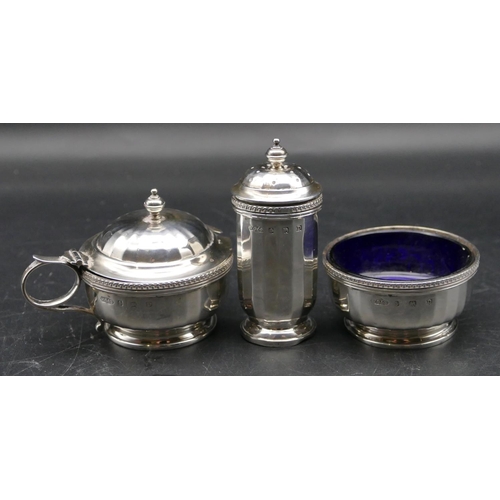 371 - A 3 piece Birmingham silver condiment set with chamfer decoration, lidded mustard pot with blue glas... 