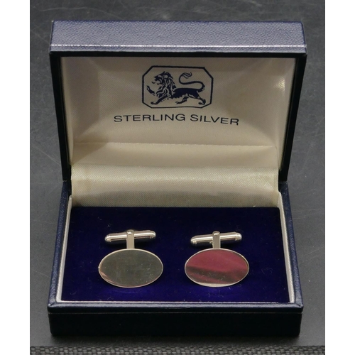 396 - A pair of modern silver oval plain gentleman's cufflinks, boxed.