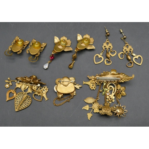 404 - A gilt metal pendant with various drop motifs, 2 similar pendants and 3 pairs of similar earrings.