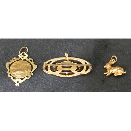 424 - A 9ct gold charm in the form of a rabbit, a gold drop St. Christopher pendant and a gold brooch (3),... 