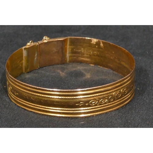 444 - A high carat gold hinged bangle with engraved decoration, inner measurement 5.7cm, 17 grams