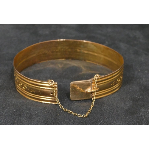 444 - A high carat gold hinged bangle with engraved decoration, inner measurement 5.7cm, 17 grams