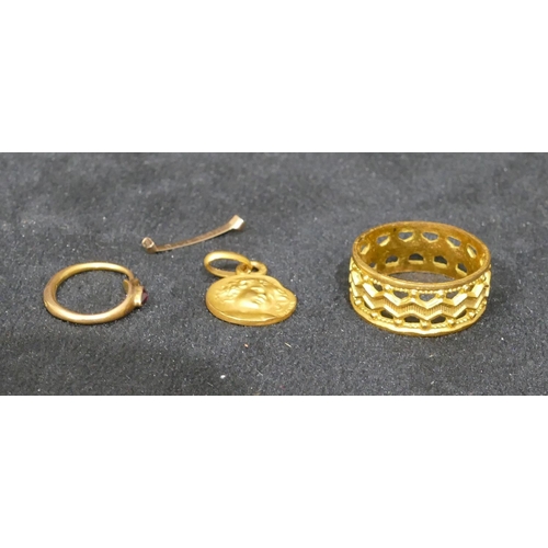 477 - A gold coloured wedding ring with pierced decoration, Size M/N, a high carat gold small pendant with... 