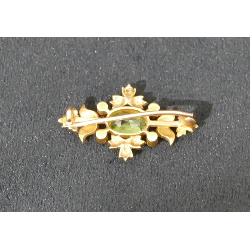 492 - A 15ct gold brooch set with centre green stone surrounded by half pearls, 3.2cm long