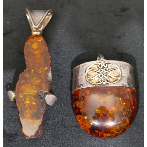 504 - A silver and amber drop pendant, 8cm long and another silver and amber drop pendant. (2)