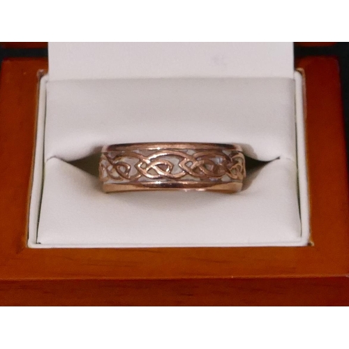 511 - A 9ct gold Clogau wedding ring with raised scroll rim, size X/Y, 9.1 grams, with original box.