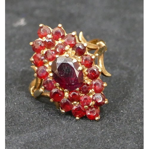 513 - A 9ct gold ladies garnet cluster ring set with centre garnets and surrounded by various smaller garn... 