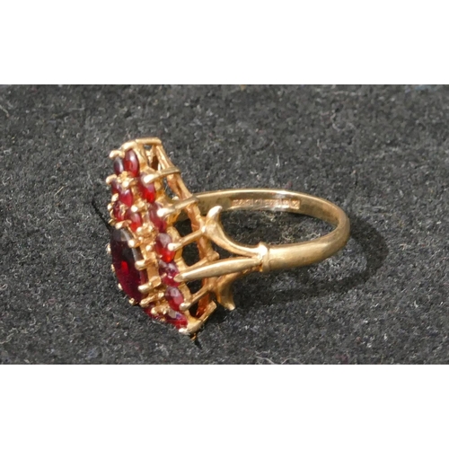 513 - A 9ct gold ladies garnet cluster ring set with centre garnets and surrounded by various smaller garn... 