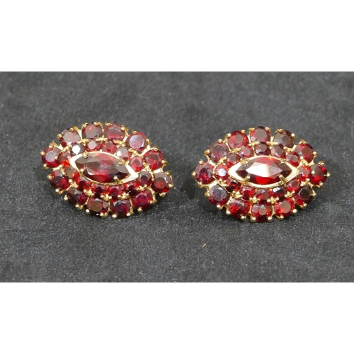 519 - A pair of 14ct oval gold earrings set with centre garnets and surrounded by smaller garnets, 3cm hig... 