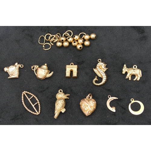 543 - 7 9ct gold charms and a small quantity of various other gold beads etc, 12 grams.