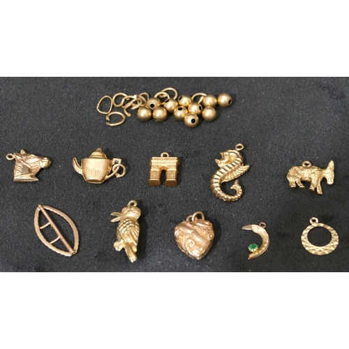 543 - 7 9ct gold charms and a small quantity of various other gold beads etc, 12 grams.