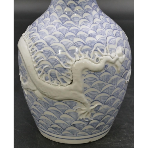 59 - An Oriental round bulbous thin necked vase with raised dragon decoration, 22.5cm high.