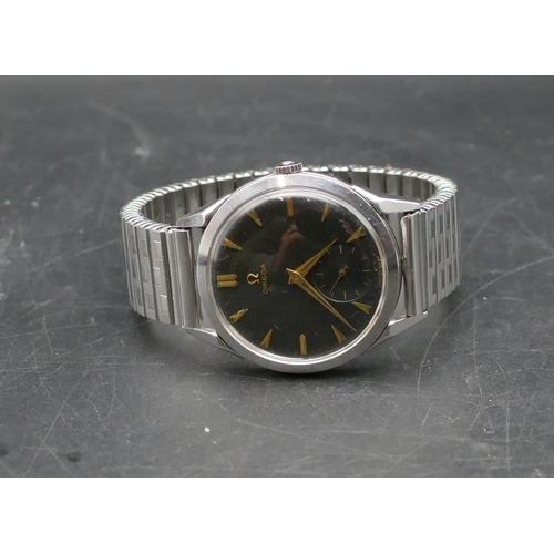 604 - An Omega gentleman's circular black-faced steel wristwatch with seconds dial, expanding strap bracel... 