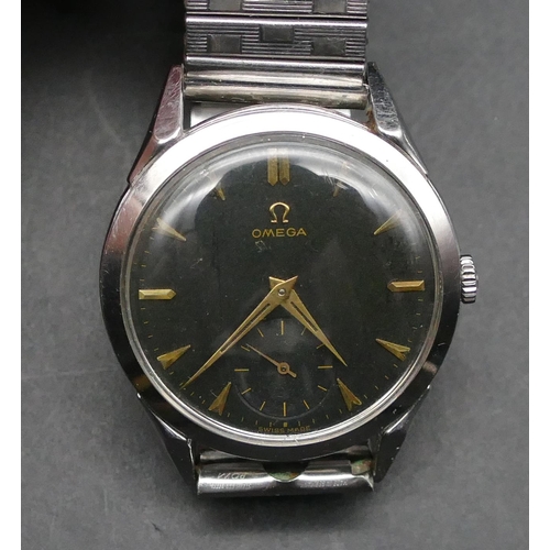 604 - An Omega gentleman's circular black-faced steel wristwatch with seconds dial, expanding strap bracel... 