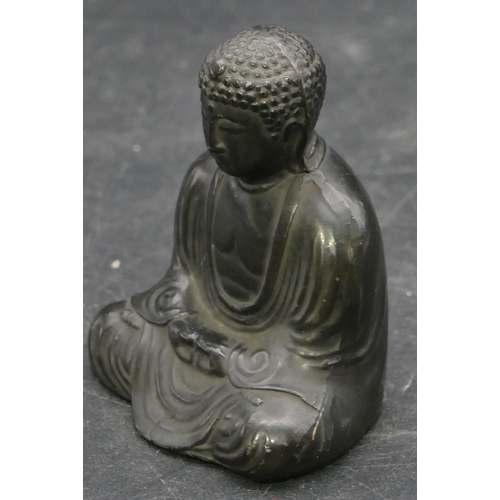 659 - A signed Oriental metal figure of seated Buddha, signed to base, 6cm high.