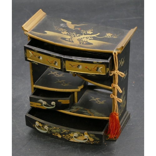 664 - An Oriental black lacquered miniature dolls house cabinet with allover gilt, crane, tree and floral ... 