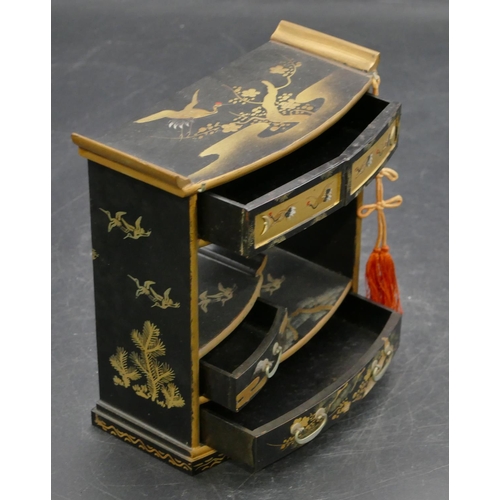 664 - An Oriental black lacquered miniature dolls house cabinet with allover gilt, crane, tree and floral ... 