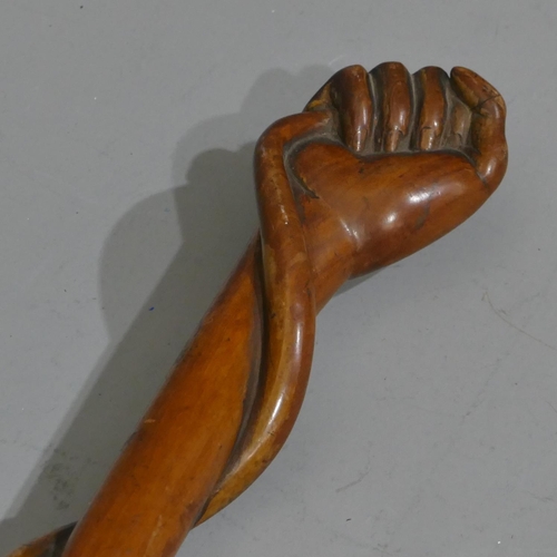 665 - A 19th Century carved wooden walking stick with hand finial clutching entwined end coiled around who... 