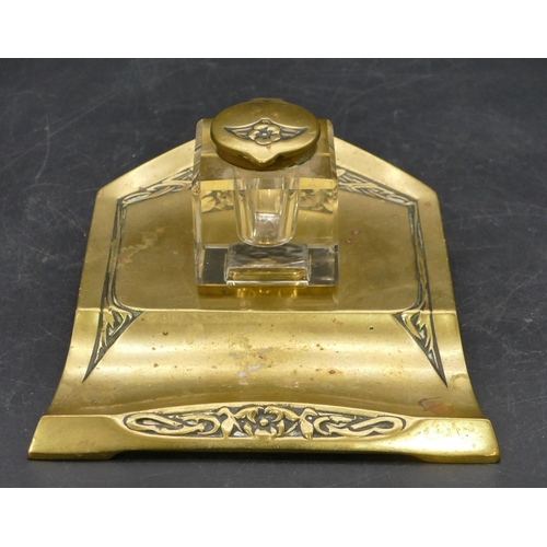 671 - An Art Nouveau style brass ink stand with square cut glass bottle and hinged lid, embossed floral an... 