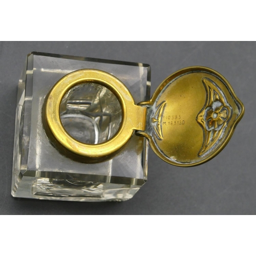 671 - An Art Nouveau style brass ink stand with square cut glass bottle and hinged lid, embossed floral an... 