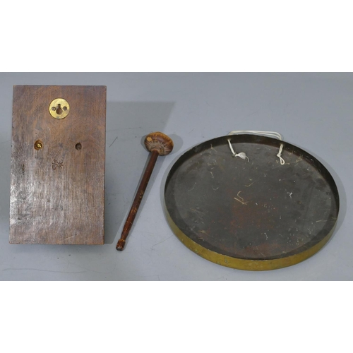 672 - A circular brass hanging gong with hammer mounted on oak panel with lion's head motif, gong 30cm dia... 