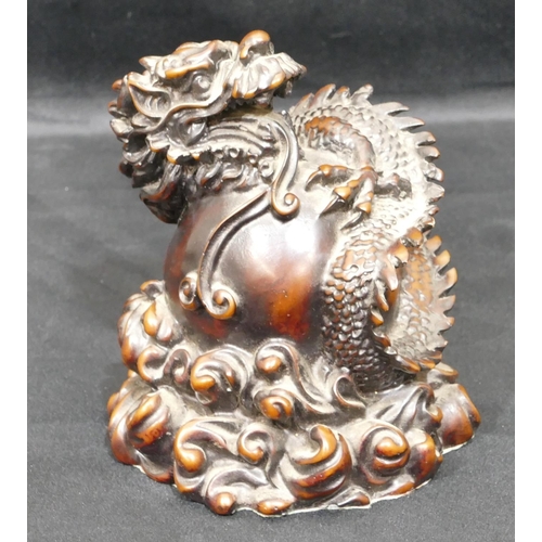 697 - A resin model of a Chinese dragon wrapped around a ball, 15cm high.