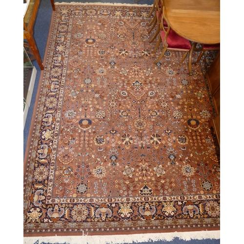 712 - A modern large Persian carpet on light terracotta ground with allover floral, leaf and scroll decora... 