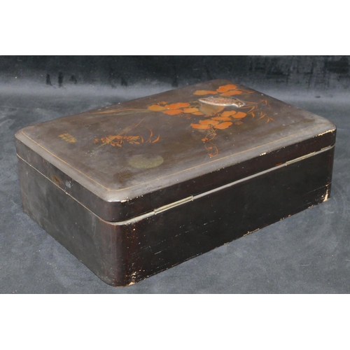 713 - An Oriental lacquered rectangular shaped box on black ground with raised bird, gilt and leaf decorat... 