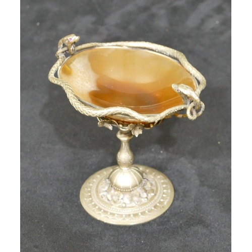 714 - A small silvered metal oval sweetmeat dish with serpent rim on turned stem with round base, 9cm high