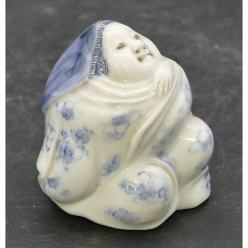 72 - An Oriental Herado china figure of a seated lady on blue and white ground, 6.2cm high.