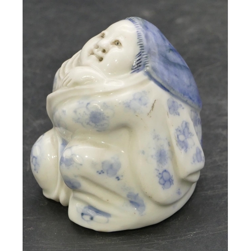 72 - An Oriental Herado china figure of a seated lady on blue and white ground, 6.2cm high.