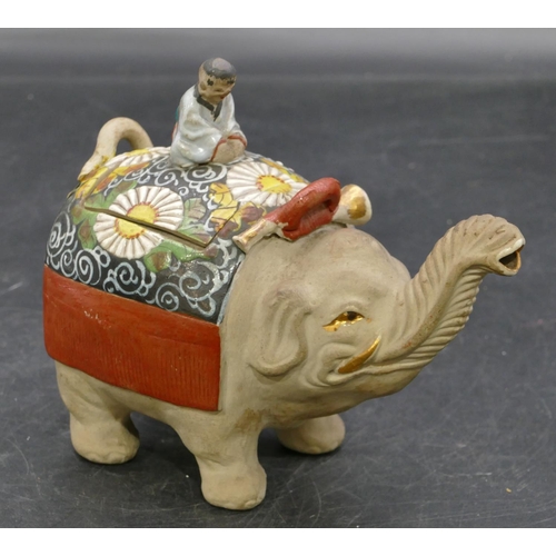 73 - An Oriental earthenware teapot in form of an elephant with cover mounted with seated figure motif, a... 