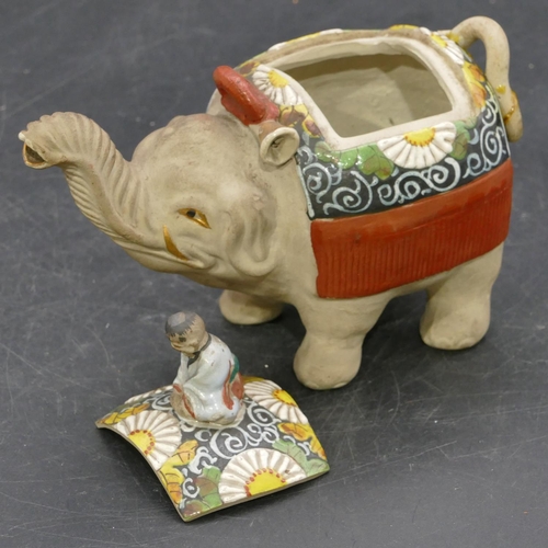 73 - An Oriental earthenware teapot in form of an elephant with cover mounted with seated figure motif, a... 