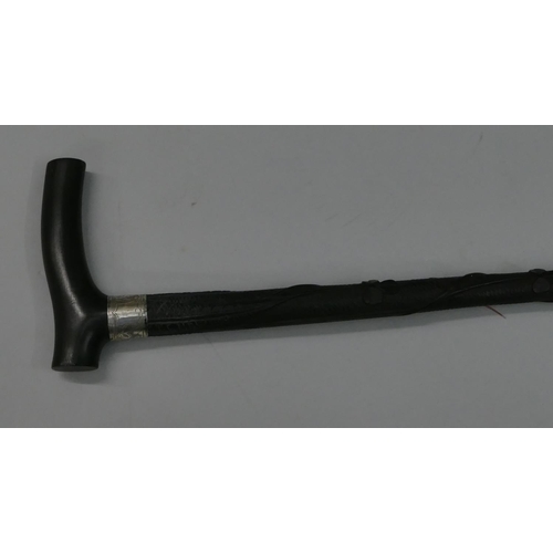 748 - An ebony walking cane with a Birmingham silver buckle neck, raised carved twist leaf decoration, 92.... 