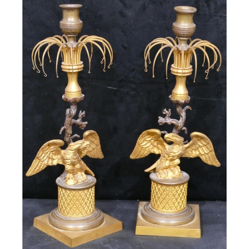 758 - A pair of 19th Century gilt metal and bronze Lustre candlesticks, with eagle motifs and standing upo... 