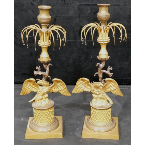 758 - A pair of 19th Century gilt metal and bronze Lustre candlesticks, with eagle motifs and standing upo... 