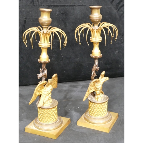 758 - A pair of 19th Century gilt metal and bronze Lustre candlesticks, with eagle motifs and standing upo... 