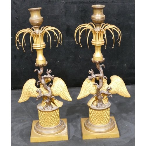 758 - A pair of 19th Century gilt metal and bronze Lustre candlesticks, with eagle motifs and standing upo... 