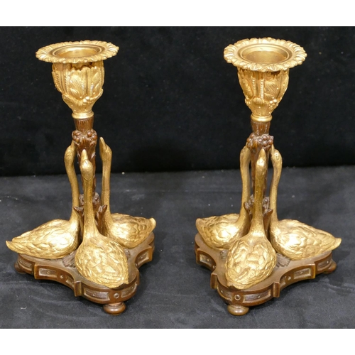 759 - A pair of bronze and ormolu candlesticks in the form of 3 swans on tripod base with bun feet, 17cm h... 