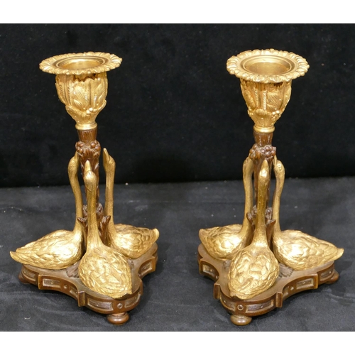 759 - A pair of bronze and ormolu candlesticks in the form of 3 swans on tripod base with bun feet, 17cm h... 