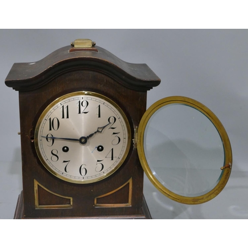 771 - A Junghans oak 8-day striking arch topped mantel clock with brass carrying handle and various mounts... 