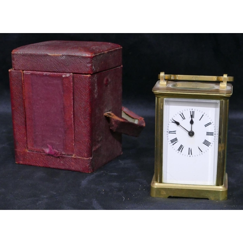 777 - A brass carriage clock with swing overhead handle, white enamel dial with Roman numerals (with key),... 